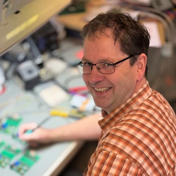 Maik Freitag bei der Elektronikentwicklung an der Werkbank mit Platinen